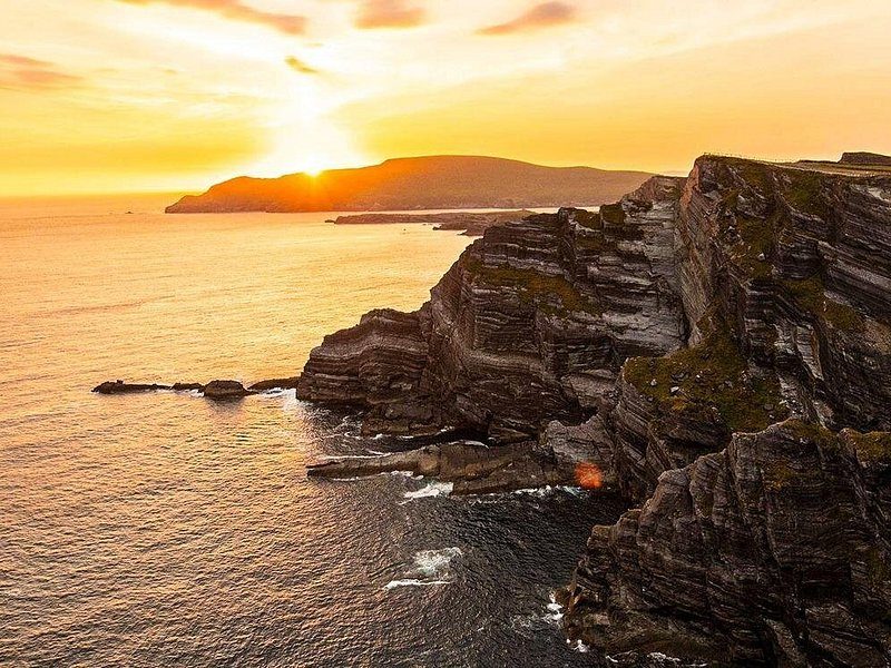 The cliff face in gold evening light, looking south along the wall