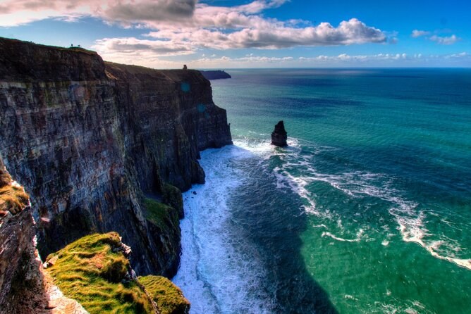 Atlantic swell breaking green at the base of the Cliffs of Moher