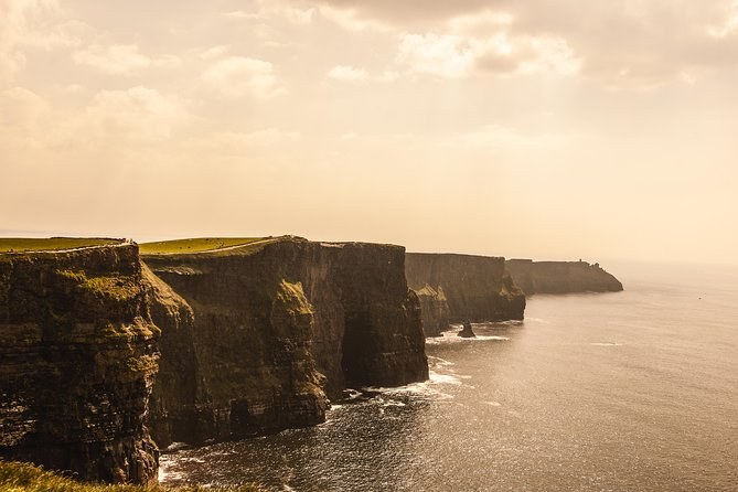 The full wall of the Cliffs of Moher under a low evening sun