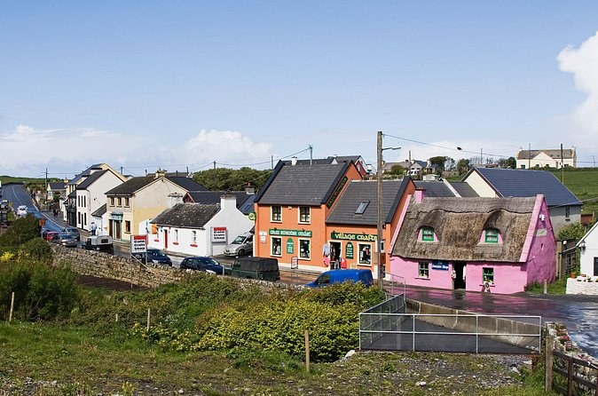 Painted shopfronts and a thatched cottage in a County Clare village on the road to the cliffs